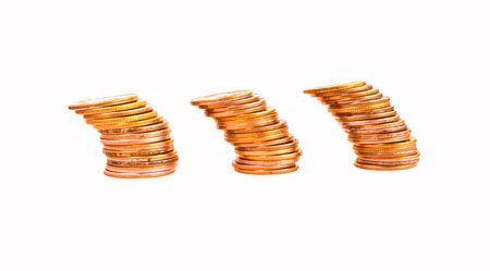 Money coins in a stack tilted to the side isolated on a white background. Coins are falling....