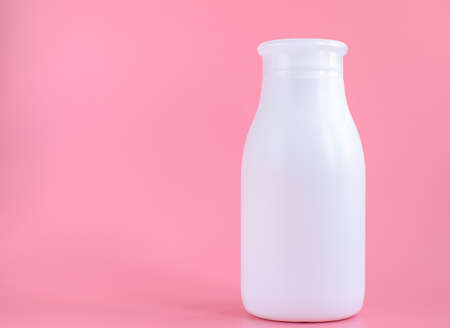 White plastic bottle for hygiene, cosmetics on a pink background. Packaging, layout, template. Copy space for text.の写真素材