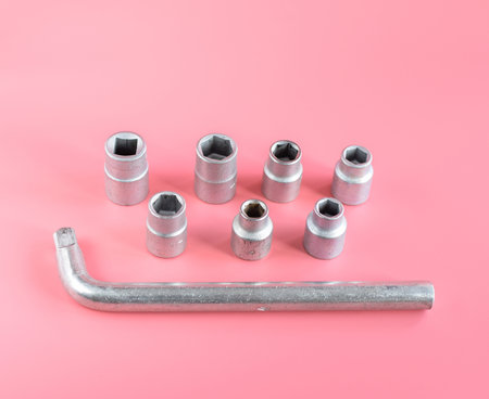 Set of sockets for tightening nuts and bolts isolated on a pink background. Locksmith assembly tool....