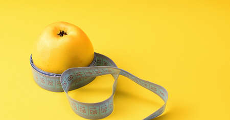 Yellow apple and centimeter tape. Healthy food concept.の写真素材