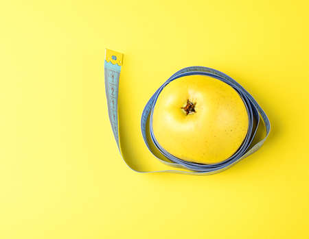 Yellow apple and a centimeter tapeの写真素材