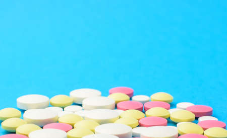 Colored pills on a blue background. The concept of medicine and protection from coronavirus....
