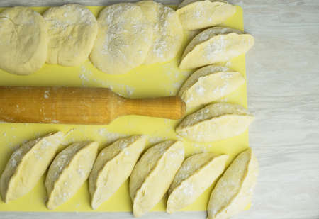 Process of making homemade pies with filling, a wooden rolling pin for the dough, on the kitchen...