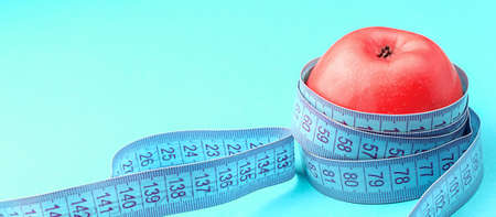 Red apple and centimeter tape. Concept of healthy and proper nutrition, diet. Side and top view....