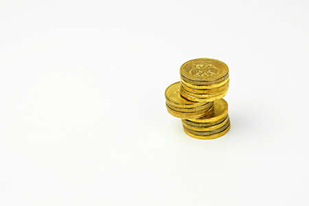 Stack of coins on a white background. Selective focus.の写真素材