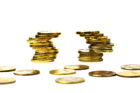 Money coins in a stack are tilted to the side, isolated on a light background. Bundles of coins...