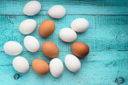 Chicken eggs. Ingredient for breakfast on a colored wooden background. Top view, flat lay.の写真素材