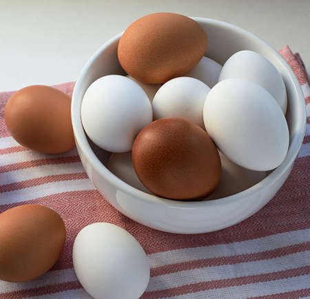 Chicken eggs. Breakfast ingredient on a colored tea towel. Top and side views. Selective focus. Blurred backdrop.の写真素材