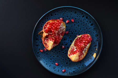 Ripe pomegranate fruits on a dark background. Healthy eating. Top view.の写真素材