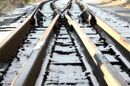 Image of an empty winter railroad track stretching far away. Crossing railway tracks. Narrow gauge...