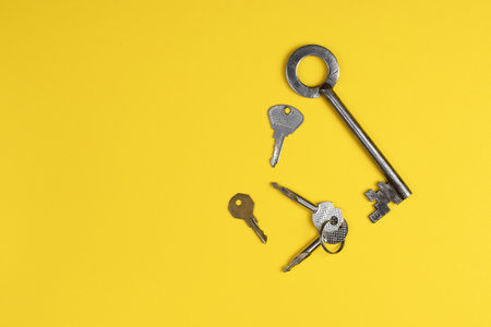 Door keys of different shapes on a bright yellow background.の写真素材