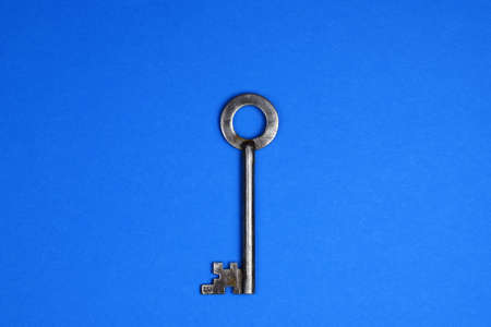 Old metallic keys isolated on blue background. Flat lay.の写真素材
