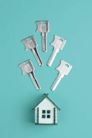House keys and miniature house model on a colorful bright background. Top view, flat lay. Home buying concept.の写真素材