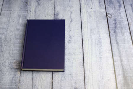 Blue notepad on a wooden background. minimalistic style. top view.