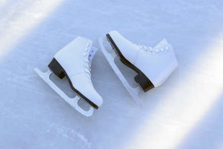 Figured female skates on an ice rink outdoors. Winter active rest and sport concept. Top view, flat lay.の写真素材