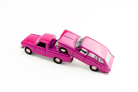 Light truck carrying a car. Two pink cars, isolated on white.の写真素材