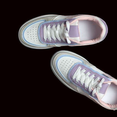 White sneakers isolated on black background. fashionable sports shoes. Top view, flat lay.の写真素材