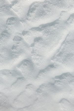 The wind creates beautiful waves on the snow. White bright snow creates a feeling of freshness. Macro image.の写真素材