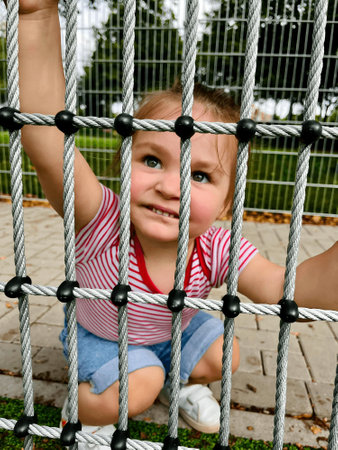 A little girl is smiling behind the fenceの写真素材