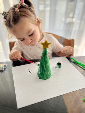 The girl paints with watercolors, childrens creativity. Traditional Christmas holiday nutcrackers figurine ornamentの写真素材