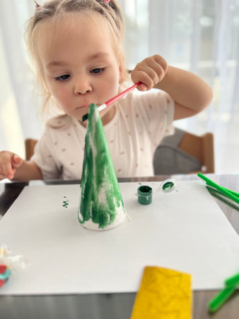 The girl paints with watercolors, childrens creativity. Traditional Christmas holiday nutcrackers figurine ornamentの写真素材