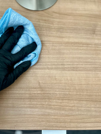 polishing glass door using microfiber cloth and yellow latex gloves.の写真素材