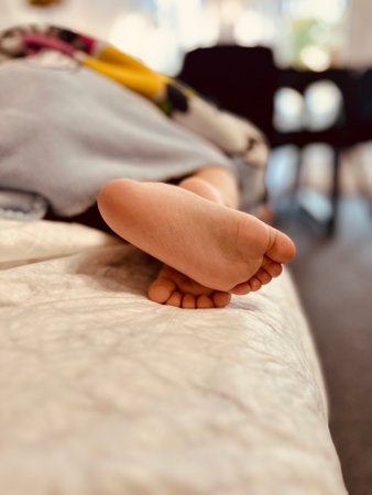 Close-up of child's bare foot captures every detail, from tiny toes to soft skin. Ideal for healthcare, hygiene, parenting content, advertisements for children's skincare or podiatric products.の写真素材