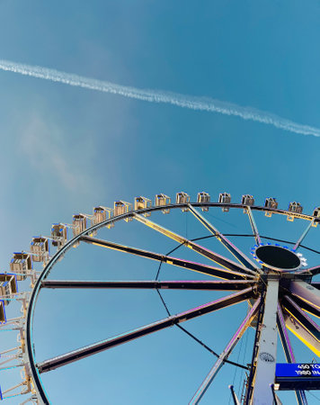 Ferris wheel on cloudy sky background vintage color.