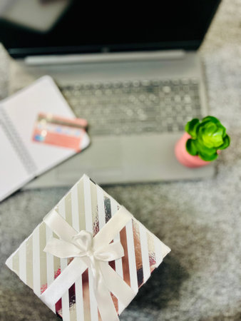 Tech gifts for Christmas for the tech-obsessed person. Gadgets and devices Xmas gift ideas. Laptop with Christmas gift boxes on the table.の写真素材