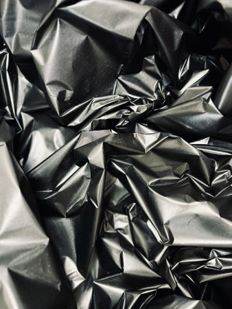 full frame abstract background of crumpled black plastic film bag.の写真素材