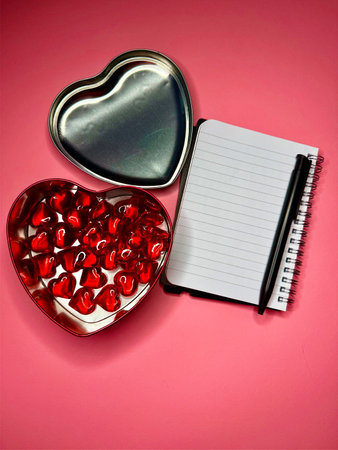 Gift box for Valentine's Day on pink background and a notebook.の写真素材