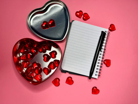 Gift box for Valentine's Day on pink background and a notebook.の写真素材