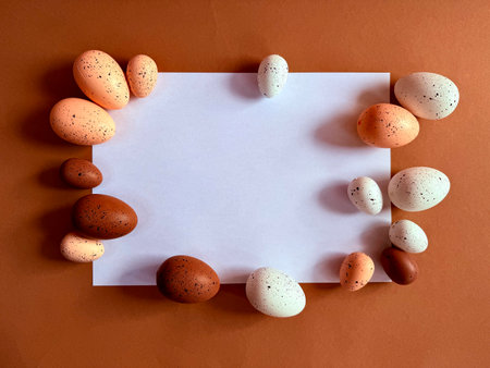 Notebook with Easter Eggs. Spiral notepad on spring beige background. Top view of open writing pad with blank page, office flat lay. White page for your writing. Copy space. Easter Mock Up. Peach Fuzz.の写真素材