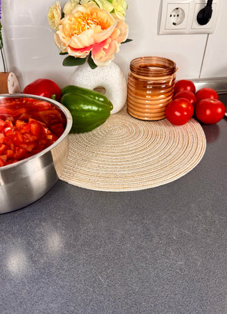 Sliced Roma Tomatoes on a cutting board with fresh plum tomatoes, basil, and a dish of pesto in the background.の写真素材