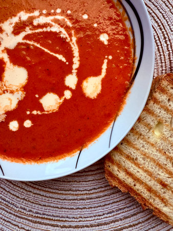 A photo of a bowl of red tomato cream soup.の写真素材