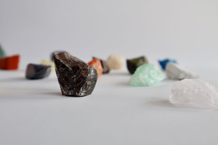 Collection of various raw colorful gemstones and minerals on a white background