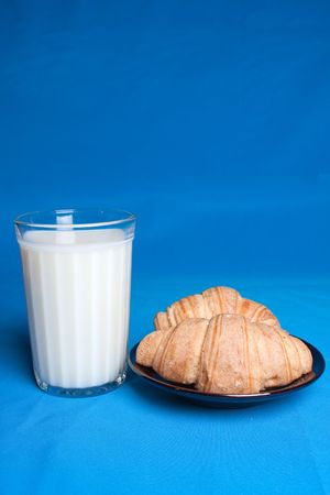 Milk in glass and croissants in a saucer.の写真素材