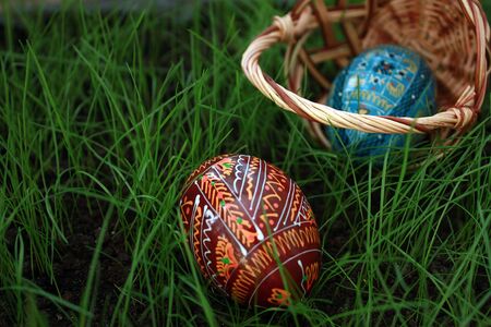 Inverted easter basket with eggs on a grassの写真素材