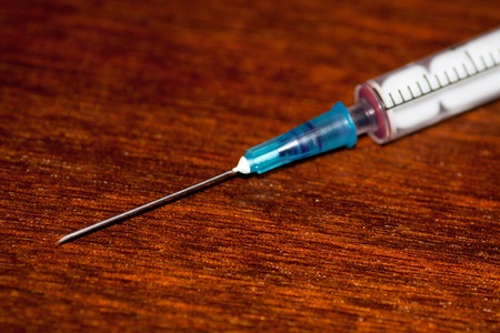 medical syringe with blood on a tableの写真素材