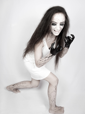 Halloween. Portrait mad girl zombie with black hands and veins on her face. concept of halloween and day of the dead.の写真素材