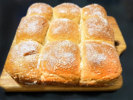 Appetizing ruddy buns with sesame seeds on a baking sheet, homemade pastries. Freshly baked wheat...