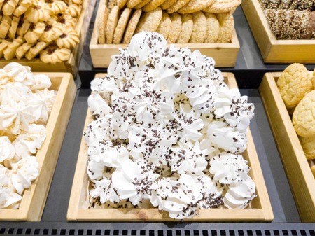 Delicious sweet meringues with nuts and chocolate and biscuits in shop windowの写真素材