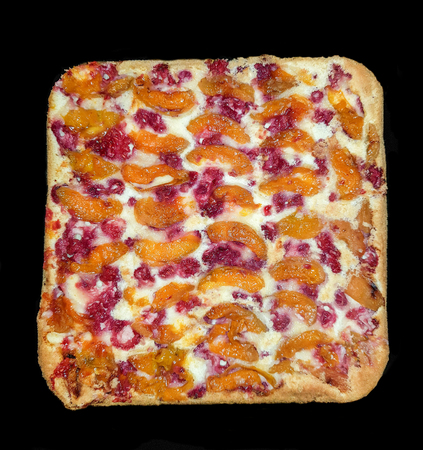 Fresh baking cake with fresh cranberries, raspberry, apples and apricots on topの写真素材
