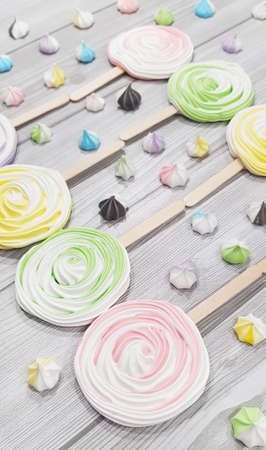 Colorful meringue lollipop on a gray background.の写真素材