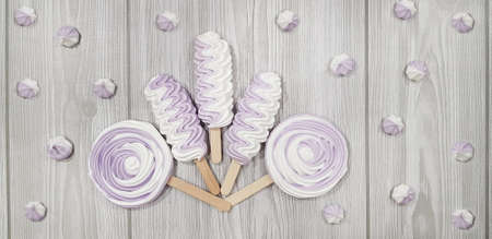 Colorful meringue lollipop on a gray background.の写真素材