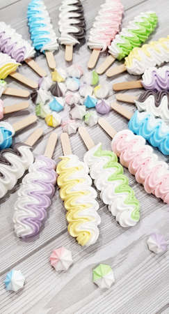 Colorful meringue lollipop on a gray background.の写真素材