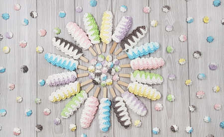 Colorful meringue lollipop on a gray background.の写真素材