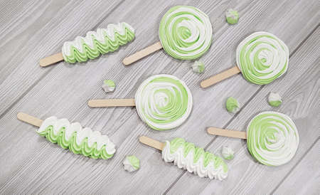 Colorful meringue lollipop on a gray background.の写真素材