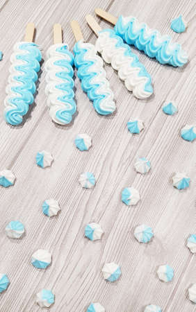 Colorful meringue lollipop on a gray background.の写真素材