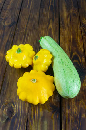 Zucchini and mini patty pan squashes on dark wooden table. Harvest vegetables.の写真素材